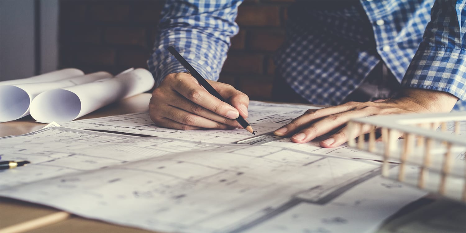 Man with blueprints - renovation budgeting concept